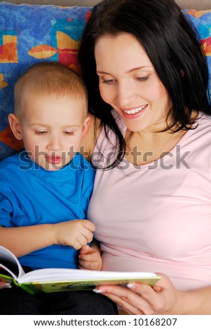Beautiful mother reading the book for little son