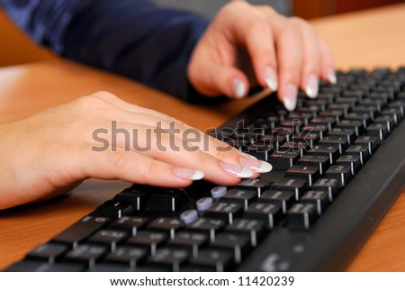 Woman typing the message on black keyboard
