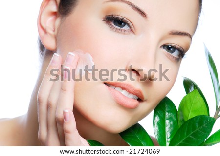 stock photo : Woman applying moisturizer cream on face.