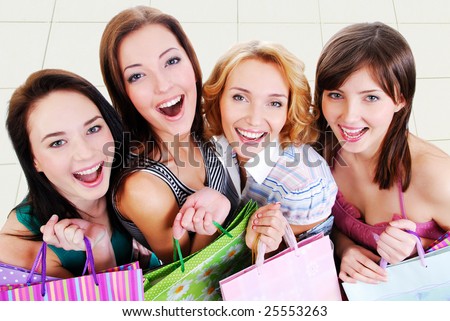 Group of happy pretty laughing girls with shopping bags, high ange view.