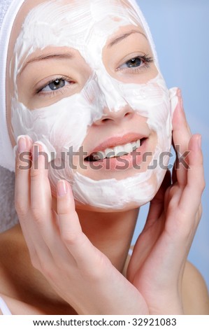 close-up young female face in cosmetic mask -  colored background