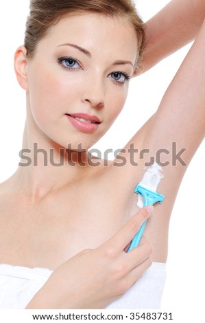 stock photo Portrait of pretty young woman shaving underarm with razor