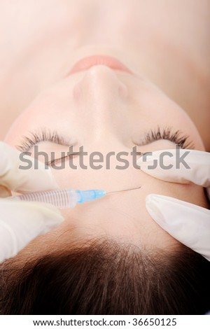 Injection to the female forehead - high angle shot