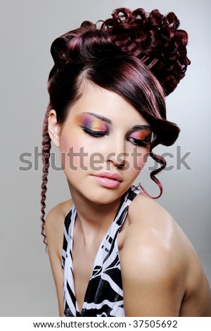 Pretty young woman with fashion creative hairstyle and bright multicolored eyeshadow
