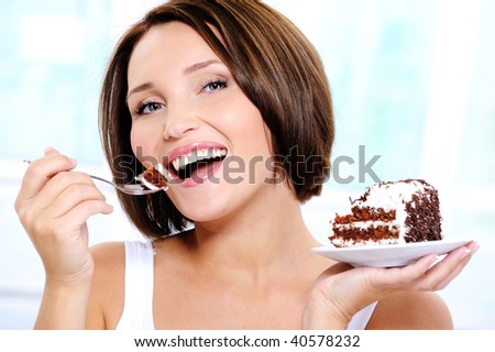 Portrait of a Happy and cheerful beautiful  young woman eats a sweet cake