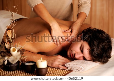 Handsome man getting massage in the beauty salon - low key light