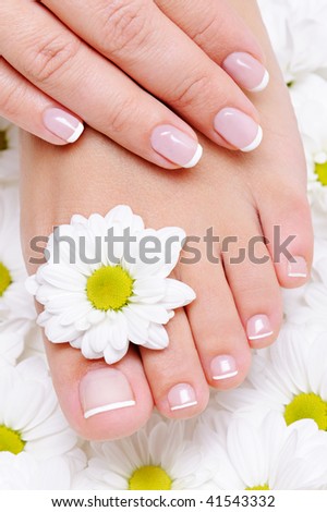 female hand with beautiful french manicure on the pure and clean foot