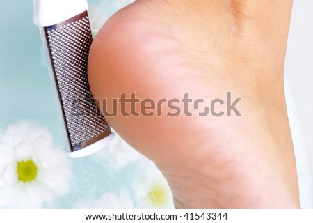 female scrubbing heel in water using clearing brush. Macro photo
