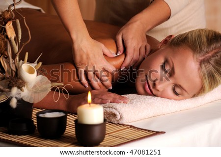 Masseur doing massage on female shoulder in the beauty salon