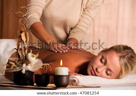 stock photo : professional masseur doing massaging back of a beautiful young 