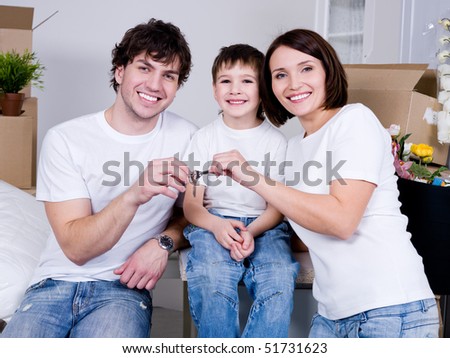 Happy young family sitting in their new flat - indoors