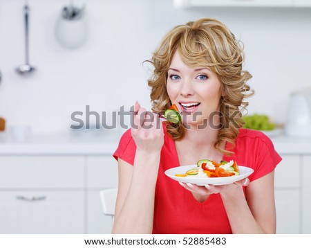 stock images women eating salad laughing. smiling woman eating salad