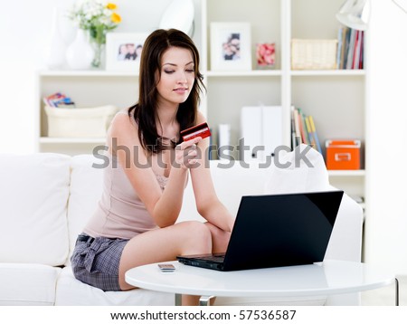 Beautiful woman sitting at home and shopping with laptop and credit card  - indoors