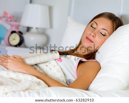 beautiful woman sleeps with the book at night in the bed