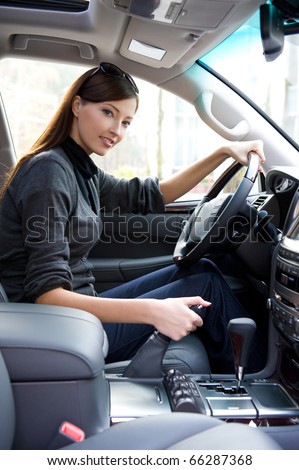 beautiful young happy woman posing inside of  the new car
