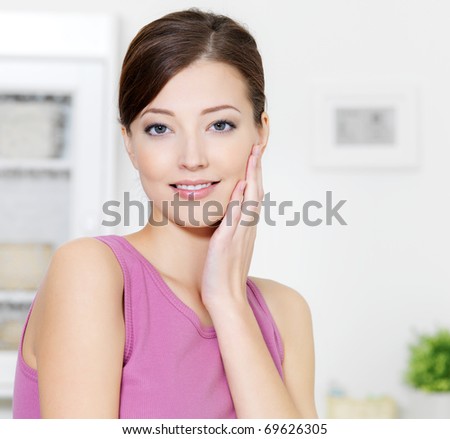Woman with clean fresh skin of face looking at camera - indoors