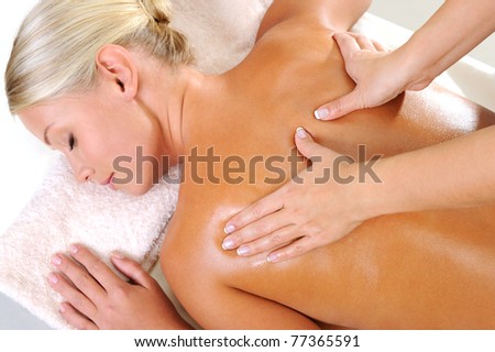 Young woman taking a massage for her body in beauty salon