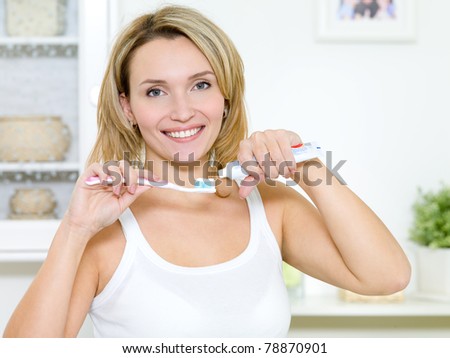 Young smiling woman cleaning teeth