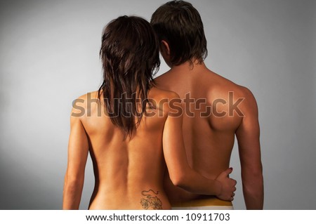 portrait of couple turned back on gray; tattoo on girl\'s back