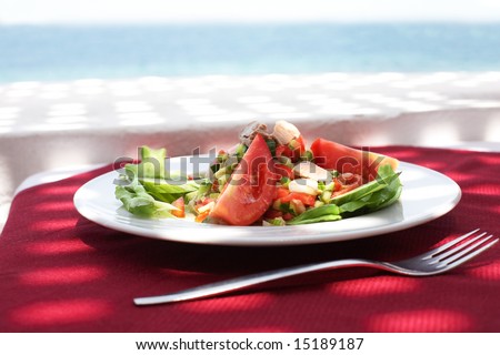 salad from tunny and fresh vegetables in restaurant on open air with sea view