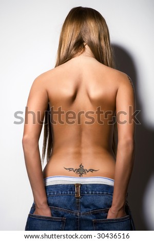 stock photo : rear view of young sexy girl, nude in jeans, tattoo on