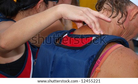 Girl giving massage to another team mate before the start of a race in a water sport event