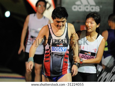 SINGAPORE - 31 May: Husband and wife ultra marathoners after crossing the finish at the Adidas Sundown Marathon held in Singapore on 30 and 31 May 2009.