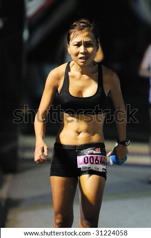SINGAPORE - 31 May: Pain in woman ultra marathoner finisher at the Adidas Sundown Marathon held in Singapore on 30 and 31 May 2009.
