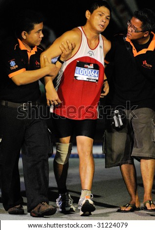 SINGAPORE - 31 May: Ultra marathoner finisher needing help after the finish at the Adidas Sundown Marathon held in Singapore on 30 and 31 May 2009.
