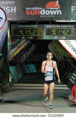 SINGAPORE - 31 May:Happy ultra marathoner crossing finish line at the Adidas Sundown Marathon held in Singapore on 30 and 31 May 2009.