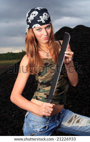 young attractive female posing with sword dressed in camouflage singlet and dark scarf
