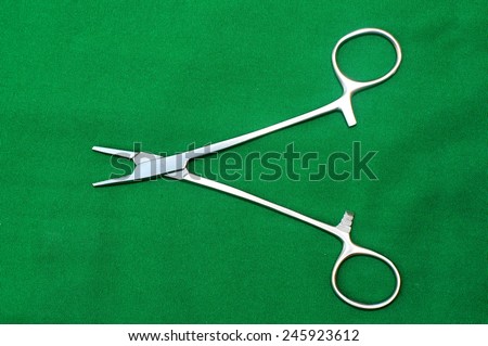 surgical clamps on a green background