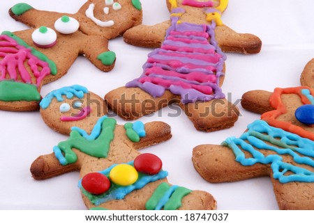 close up of brightly colored gingerbread men cookies against a white background