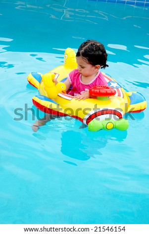 cute toddler girl in plane inflatable toy in swimming pool