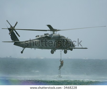 UH-60 Black Hawk. Soldier climbing up ladder on to A UH 60 Black Hawk which is a utility tactical transport helicopter .