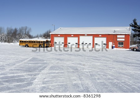 Red garage with school buses