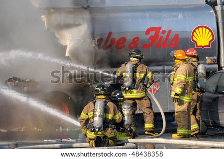 GRANBY, QC, CANADA - MARCH 10: Firemen fighting a fire on tank trucks at a gas station March 10, 2010 in Granby, QC, Canada.