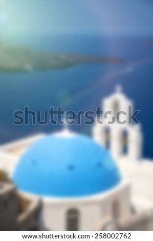 A blurred background image of one of the most famous churches on santorini situated in the village of firostefani.