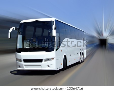 A white tour bus set against a motion blurred background