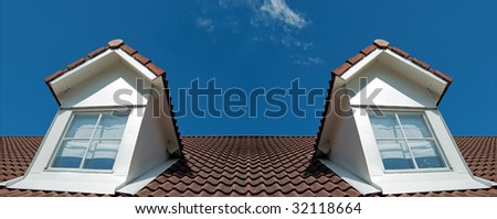 Two second floor dormer windows situated on a house roof.