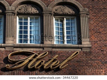 An unlit neon hotel sign situated under the room windows
