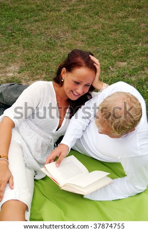 A young man reads poetry to his beautiful partner during a romantic picnic