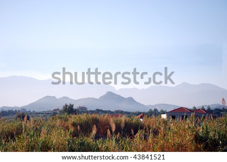 A dramatic view of the mountain range on the greek island of crete with an abandoned hotel complex in the foreground.