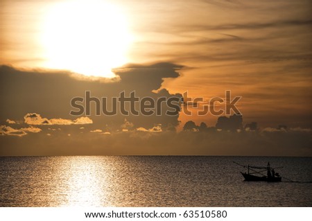 A fishing boat off Thailand sets sail at sunrise to gather it\'s hopefully full nets and baskets.