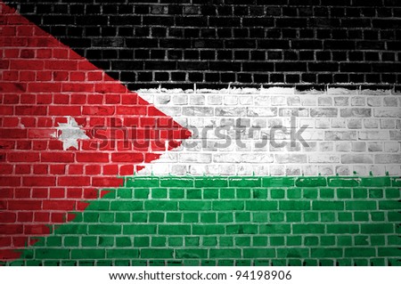 An image of the Jordan flag painted on a brick wall in an urban location