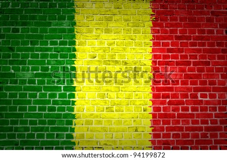 An image of the Mali flag painted on a brick wall in an urban location