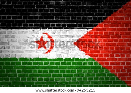 An image of the Western Sahara flag painted on a brick wall in an urban location
