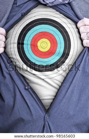 A businessman rips open his shirt and shows how perfect he is for your needs by showing off a target printed on a t-shirt