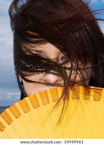 woman portrait hiding fan wind yellow long hair