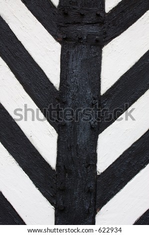 Decorative panel details on the exterior of a Tudor / medieval half-timbered black and white building.